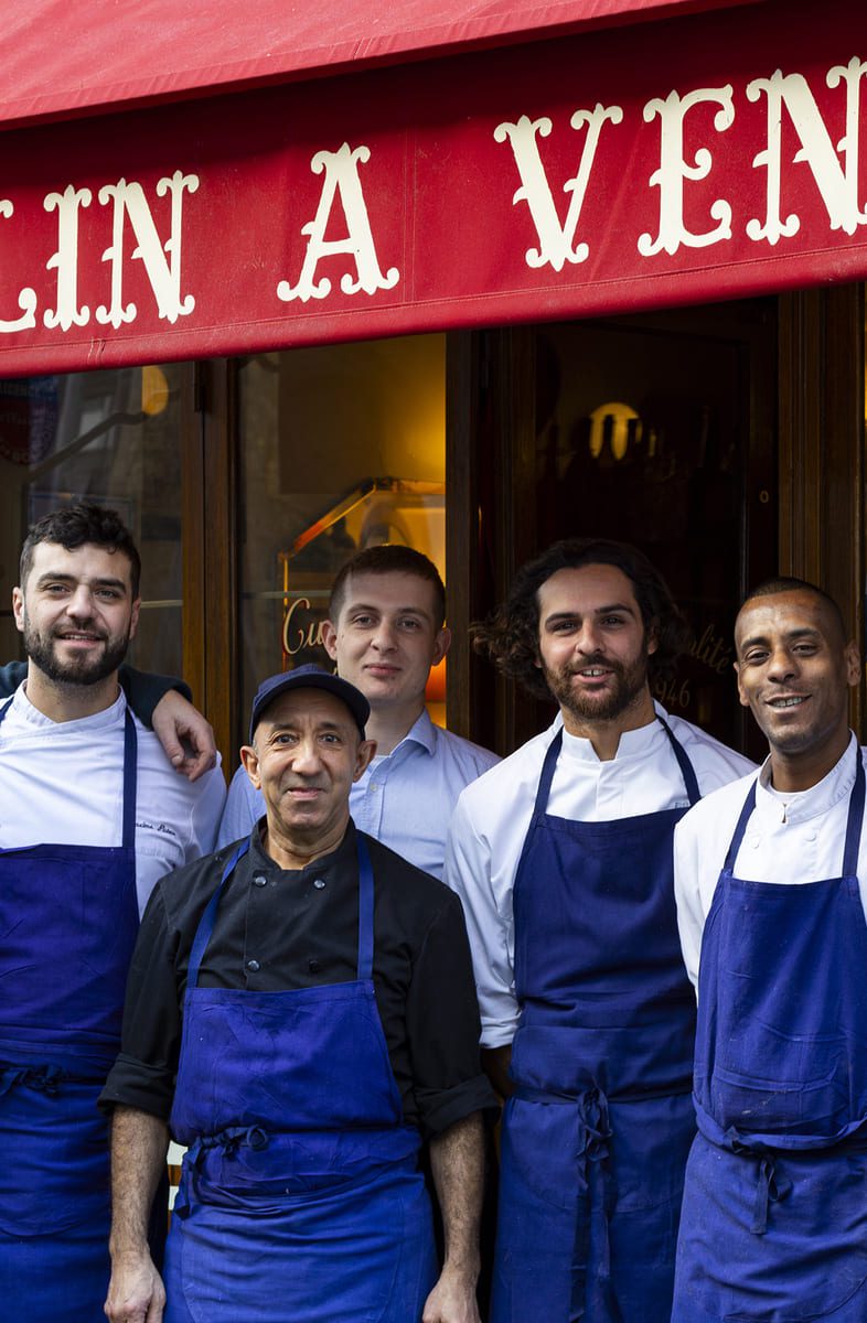 Tour group with restaurant staff outside Au Moulin à Vent bistro