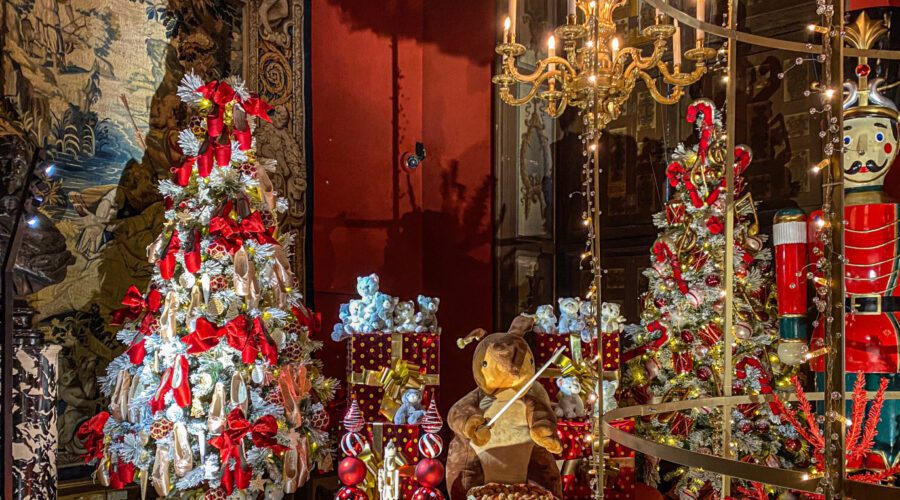 Lavish Vaux-le-Vicomte room decorated for Christmas with trees, toys, gifts and a giant nutcracker under warm candlelight