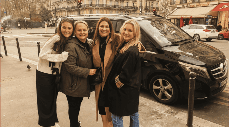 Four women beside Paris and Beyond Tours luxury van during Paris Your Way full-day private tour