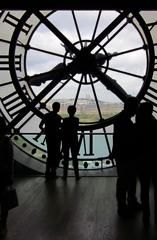 Visitors silhouetted at Musée d'Orsay's iconic clock overlooking Paris - Sylvanie's favorite tour location